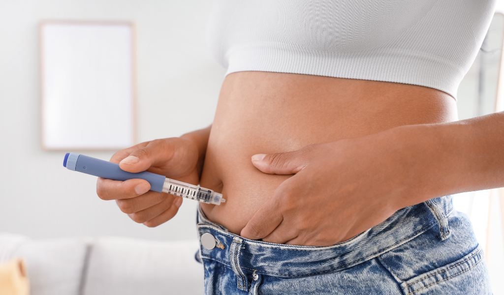 Mulher aplicando a caneta na barriga