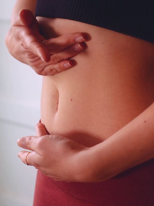 Mãos massageando a barriga